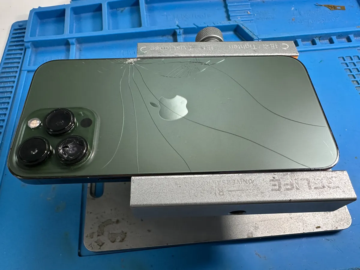 iPhone with cracked back glass on the repair mat