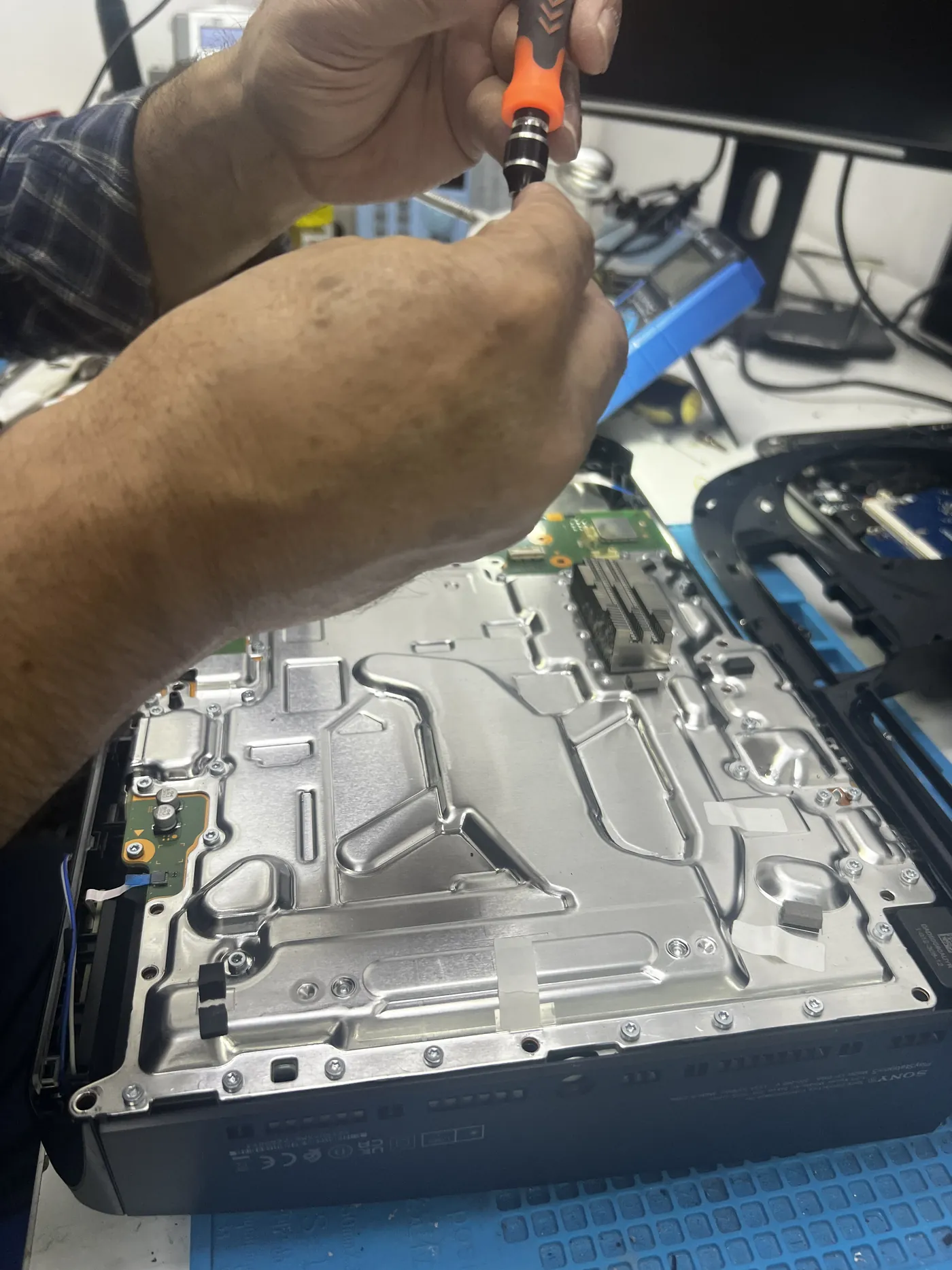 Laptop being disassembled with tools on an anti-static mat