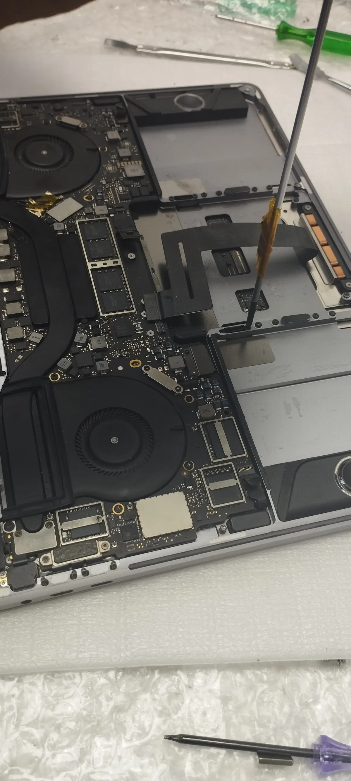 MacBook logic board exposed during component-level repair